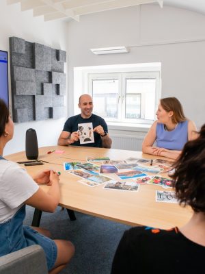 Photo by Walls.io a group of people sitting around a wooden table
